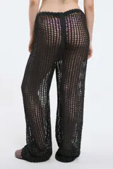Pantalón blanco de tejido calado, con cintura elástica y cordón ajustable, de corte recto y holgado.