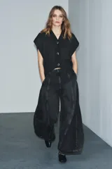 Jeans de tiro alto con diseño de pierna tipo balloon, confeccionados en denim de color gris oscuro con efecto lavado. Presentan costuras verticales marcadas a contraste, bolsillos laterales ocultos y cierre lateral con cremallera.