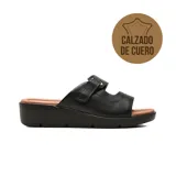 Sandalias casuales Usaflex modelo Briana, color negro con plataforma corrida y plantilla acolchada en tono suela. Poseen capellada de cuero con tiras anchas y ajuste con velcro.