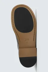 Bota tipo derby con cordones, confeccionada en piel lisa con horma cuadrada y suela con ligero tacón.