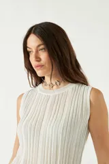 Musculosa de punto acanalado en color beige con acabado brillante, de corte al cuerpo y cuello redondo.