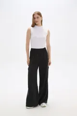 Pantalon de corte amplio y tiro alto, confeccionado en poliester, con bolsillos laterales tipo cargo.