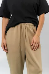 Pantalón jogger de calce relajado color bordó intenso, con cintura elastizada y lazo regulable. Cuenta con bolsillos laterales con cierre invisible y silueta recta levemente afinada.
