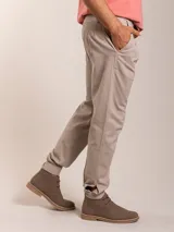 Pantalón bombacha color beige, de sarga, con pinzas en la cintura y corte tapered.