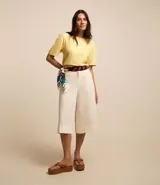 Blusa de viscolino color amarillo pálido, con cuello redondo y mangas cortas abullonadas.