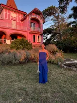 Pantalón de corte amplio y tiro medio, confeccionado en tela crepe color beige, con diseño fluido y holgado.