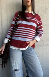 Sweater fluido de punto con diseño de rayas horizontales en color bordó y celeste, de manga larga y cuello redondo.