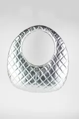 Cartera de mano ovalada con asa circular integrada, color plateado, con diseño acolchado y pespuntes romboidales.