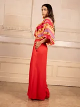 Pantalón palazzo negro de lino con cintura elástica, bolsillos laterales y cinturón con hebilla circular.