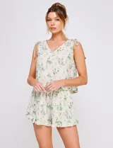 Short de lino y viscosa color beige con estampado botánico en tonos verde agua, tiro alto con cintura elastizada, corte holgado y ruedo con volado fruncido.