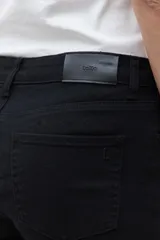 Pantalón slim fit color negro, con cierre de botón y cremallera, y bolsillos traseros.