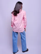 Camisa de corte holgado confeccionada en algodón, con diseño bicolor que combina blanco y celeste. Presenta cuello clásico, cierre frontal con botones, mangas largas con puños abotonados y dobladillo redondeado.