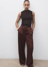Pantalón de tiro medio en tejido satinado con efecto arrugado y diseño recto. Cuenta con bolsillos laterales, pinzas delanteras y cierre oculto con botón, gancho y cremallera.