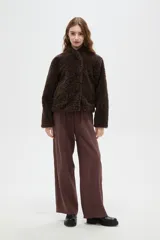 Tapado de textura tipo corderito en color marrón, con cuello solapa y cierre frontal de botones.