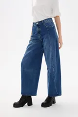 Pantalon de jean estilo barrel con tiro alto y bolsillos laterales. Presenta un corte amplio y relajado en las piernas con un lavado azul clásico.