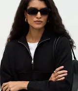 Buzo de modal color negro, con corte oversize, cuello alto con cierre frontal, mangas largas y recortes estructurados en el cuerpo.