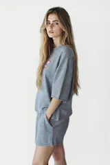 Remera gris de corte cropped con cuello redondo y manga corta. Estampado rectangular en el pecho con texto "Western Avenue Champions".