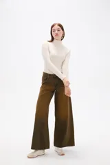 Pantalon de jean de corte ancho y tiro medio, con efecto de lavado desgastado en tonos marrones y verdosos. Cuenta con bolsillos laterales y traseros.