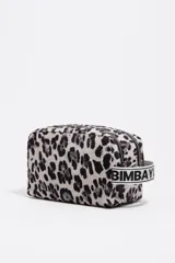 Neceser de gran tamaño con exterior de nylon estampado animal print (leopardo) en tonos rosa fuerte y negro. Presenta estructura soft, cierre con cremallera, logo metálico BIMBA Y LOLA y bolsillo interior. Incluye una etiqueta de tejido con el nombre de la marca y una correa lateral de tela blanca con texto negro.
