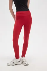 Calza deportiva de tiro alto, color rojo, confeccionada en poliamida con ajuste al cuerpo.
