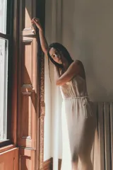 Vestido midi semitransparente de viscosa con escote recto y tirantes finos. Presenta bordados florales a contraste en el pecho y detalle de lazadas ajustables en los laterales.