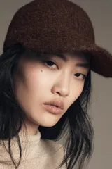 Gorra con visera confeccionada en tejido de punto con textura suave y acabado afelpado.