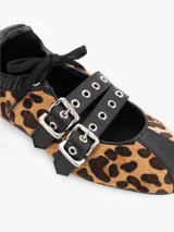 Mary Jane Iris Wild de pelo sintético con estampado animal print de leopardo y detalles en cuero vacuno negro. Cuenta con tiras cruzadas con hebillas metálicas y una base plana de 1 cm.