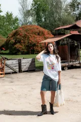 Remera blanca de algodón con cuello redondo y mangas cortas. Estampado frontal con diseño de cócteles y texto "Summer Babe Cocktail Club and Chill".