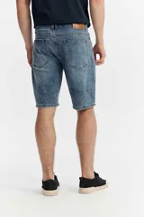 Bermuda de denim de corte relaxed fit, tiro medio y color negro con efecto deslavado. Cuenta con bolsillos clásicos y cierre frontal con botón y cremallera.