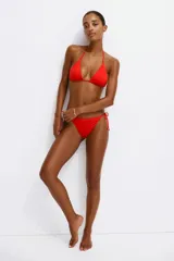 Top de bikini triangular color rojo, con relleno extraíble, tiras ajustables para atar en el cuello y la espalda, y detalle de cuentas en el frente.