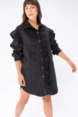 Camisa larga negra de pana fina, con cuello camisero, cierre frontal con botones, mangas largas con puños abotonados y ruedo redondeado.