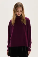 Polera de tejido de punto color azul, con cuello alto, manga larga y puños acanalados.