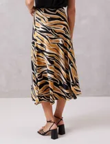 Falda midi de satén con estampado tribal en tonos negro, beige y mostaza. Presenta un corte fluido y cintura elastizada para mayor comodidad.