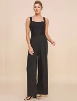 Top crop negro de corte ajustado y estructurado, con escote corazón, tirantes anchos y textura acanalada fina con costuras estilo corsé.