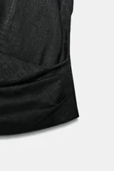 Camisa color crudo confeccionada con lino, de corte holgado, cuello solapa y escote en V. Tiene manga sisa y detalle de pliegue en el delantero. Cierre frontal con botón.