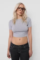 Remera baby tee gris de algodón con lycra, corte al cuerpo y mangas cortas.