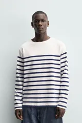Remera de manga larga de corte relaxed fit, con diseño a rayas horizontales azul marino sobre base blanca y cuello redondo.