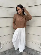 Sweater color crema tejido con diseño en ochos y cuello redondo.