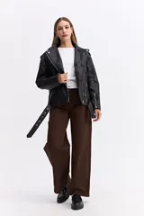 Campera estilo biker de cuero sintético negro con cierre frontal cruzado, solapas amplias, bolsillos con cierre y cinturón ajustable en la base.