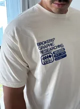 Remera beige de manga corta con estampado gráfico en azul en la espalda que incluye el texto "BROKERS GRAPHIC RESEARCHING" y "THE NEW WAVE BROKERS".