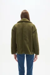 Campera corta de corderito color verde militar, con cuello solapa y cierre cruzado con botones marrones.