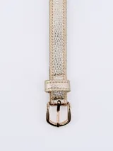 Cinto dorado con hebilla metálica rectangular.