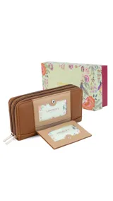 Billetera larga de diseño combinado en tonos terracota y beige, confeccionada en material sintético con textura tipo gamuza y lisa. Cuenta con cierre perimetral, solapa frontal con broche a presión y visor para documentos, además de múltiples compartimentos internos para tarjetas, billetes y monedero con cierre.