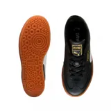 Championes urbanos Puma modelo Palermo Platform, color negro con franja lateral blanca y suela de plataforma color caramelo. Presenta detalles en dorado en la lengüeta y el lateral.