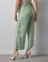Pantalón de lino color crudo, de corte ancho y largo cropped, con bolsillos laterales.