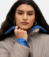 Campera puffer Marfinno con estampa de cuadros mini en tonos beige y negro, de corte recto, cuello alto y cierre frontal con cremallera. Cuenta con mangas largas y forro interior.