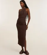 Vestido de largo midi confeccionado en tejido de rib color marrón. Presenta un diseño de hombro único y fruncido lateral que realza la silueta.