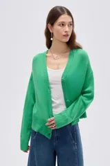 Cardigan de punto color marrón, con cuello en V profundo, cierre frontal con botones y diseño holgado de manga larga.