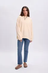Pantalon de jean cropped flare en color azul medio, de corte ajustado en la parte superior y ligeramente acampanado en los tobillos con terminación deshilachada.
