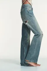 Jeans de tiro bajo y cinco bolsillos, de pierna ancha y larga. Cuenta con cierre frontal con cremallera y botón metálico.